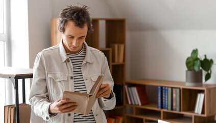 Young man reading book in library