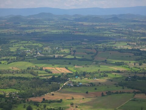Large, open field with a few houses scattered throughout