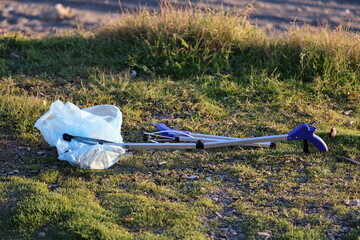 Naklejka premium Litter pickup tool. Trash grabbing tool.Volunteers cleaning up trash in nature.