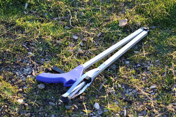 Litter pickup tool. Trash grabbing tool.Volunteers cleaning up trash in nature. © Broker_Aleksandr