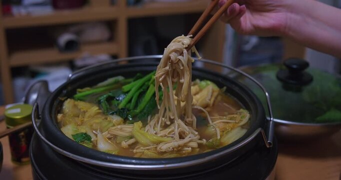 Enoki Mushrooms Lifted from Japanese Nabe Hot Pot Closeup
