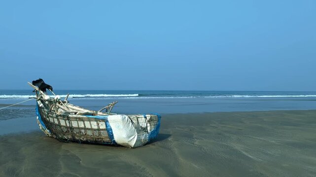 Static Wide Shot of a Weathered Fishing Boat Against a Clear Blue Sky and Horizon at cox's bazar