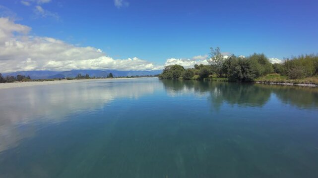 FPV drone flying close to calm lake with tree reflections in Hokitika, West Coast of New Zealand&rsquo;s South Island.

