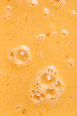 Fresh beaten eggs with bubbles as food background