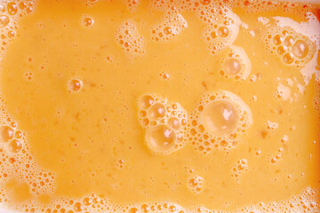 Fresh beaten eggs with bubbles as food background