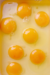 Fresh raw eggs with visible yolks on light background