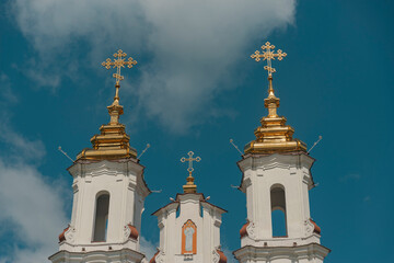 Golden domes of Resurrection Church in Vitebsk against blue sky with copy space