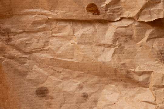 Crumpled paper bread packaging with greasy stains for the topics of food packaging, paper contamination, oil stains, and kraft paper