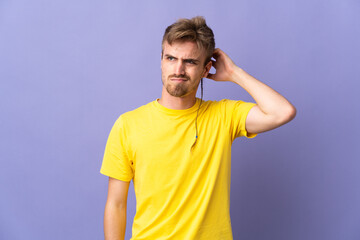 Fototapeta premium Young handsome blonde man isolated on purple background having doubts while scratching head