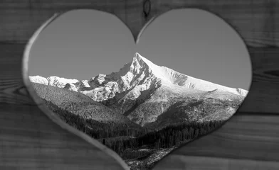 Fotobehang Hokusai The Great Wave Massive wooden panel with a precisely carved heart revealing a snow-covered rocky mountain peak in the background. Love for the mountains captured in a single frame — a view where love moves mountains  © Rastislav Sedlak SK