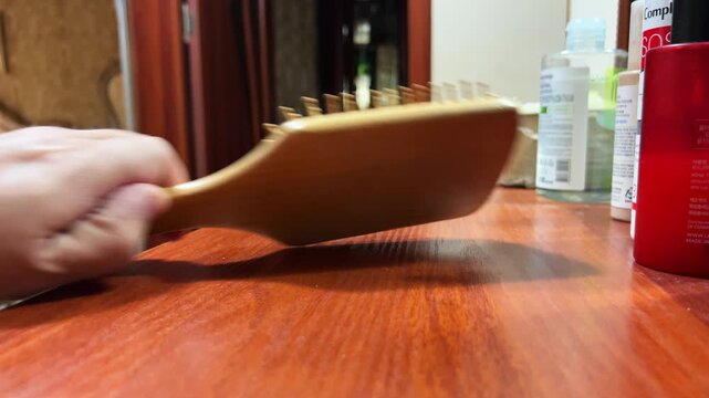 Close-Up of Female Hand Taking Hairbrush From Vanity