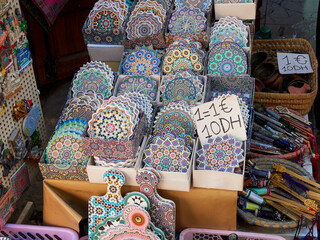 Shops in the Marrakech souk are filled with a variety of items: clothes, shoes, food, jewelry, and...