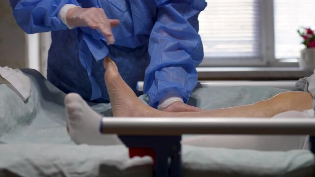 Medical Foot Massage and Joint Mobilization. Close-up of a medical professional performing manual therapy and therapeutic massage on a patient foot. Elderly care, caregiving and nursing