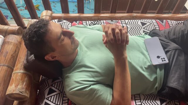 man sleeping outdoors on the terrace in funny unnatural pose travel meditation 