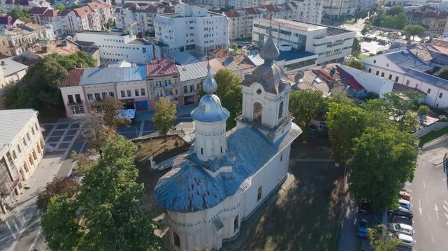 Close aerial orbit of church towers and rooftop details at dusk. Botoșani, Rom&acirc;nia.