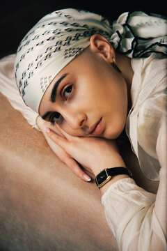 Portrait of a bald young woman with natural beauty and confident expression, isolated on neutral background. Concept of individuality, strength, self-acceptance, oncology awareness, alopecia