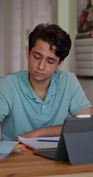 College student works through math and science problems at home, switching between a calculator and tablet while taking notes, with subtle lateral camera movement, vertical format.