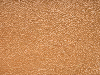 Fototapeta premium Orange quality leather, natural material with design lines pattern. Can use wallpaper or backdrop luxury event, design upholstered furniture, clothing. Genuine soft brown leather texture closeup.