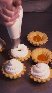 The pastry chef spreads jam on cookies. Vertical video.