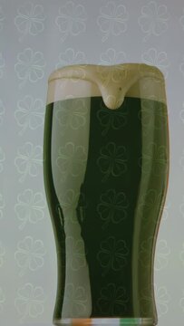 Vertical video: Pint glass entering centering dark beer foam forming drip settling showing dynamics