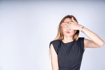 The model is making a blind eye gesture.

