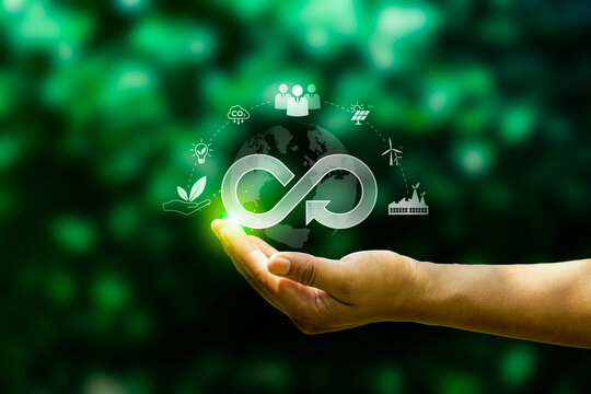 Hand presenting circular infinity symbol over globe with sustainability icons, representing circular economy, ESG strategy, renewable energy, and corporate responsibility for a greener future
