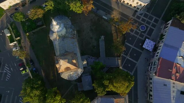 Top down aerial of Romanian church, historical center in glowing sunset - 4k