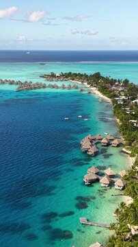 Bora Bora Island, French Polynesia. Vertical Drone Shot of Matira Beach and Luxury Resort With Villas Over Lagoon Water