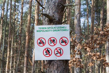 Tablica zakazów w lesie na pniu drzewa, teren spółki leśnej, zakaz wjazdu pojazdów i rozpalania ognia, ochrona przyrody. © Henryk Guziak