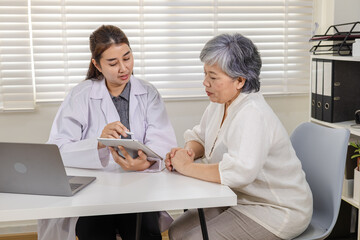 Fototapeta premium Senior, doctor, healthcare, elderly, medical patient consultation at clinic with laptop patient smiling diagnosis update, symptom assessment, review record chart follow up care. senior healthcare
