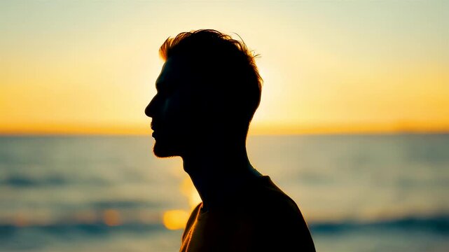Silhouette man profile against vibrant orange sunset over calm ocean horizon serene peaceful moment golden hour beach contemplation