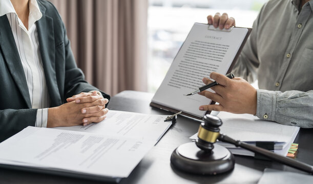 Lawyer Legal counsel presents to the client a signed contract with gavel and legal law. justice and lawyer Business partnership meeting concept