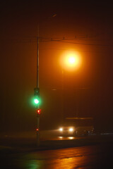 White car. Night street in the fog in the light of streetlights in the city, photo at night