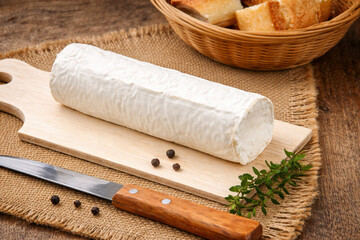 bûche de fromage de chèvre sur une planche à découper