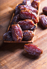 Fototapeta premium Ripe dates on an old wooden table.