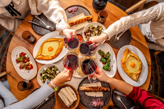 Friends toasting red wine at dinner