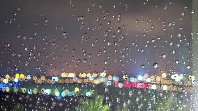 Raindrops on window glass with city bokeh