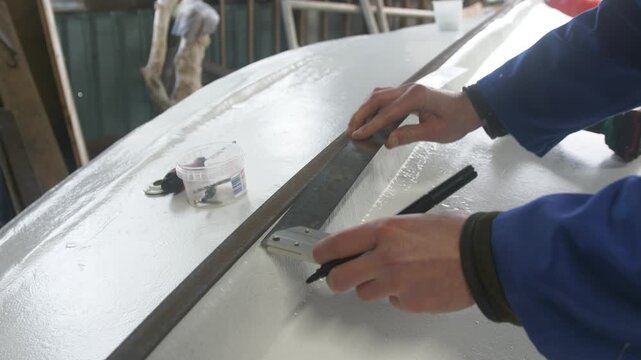 Marking along steel keelband to secure to fiberglass boat