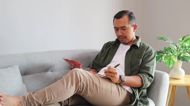 Asian man counting cash rupiah banknotes, planning budget and expenses. Rich male person holding money in hands, incomes and salary, save money and control payment