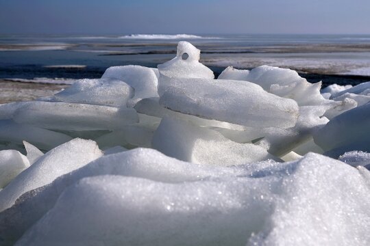 Piled ice on the shore of Baltic Sea in Puck Bay in early spring day. Oslonino, Pomerania, Poland