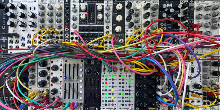 modular sound synthesizer eurorack system with colorful patch cables widescreen banner