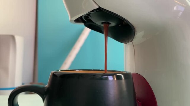 home coffee maker dispensing a fresh espresso stream into a cup, crema forming on top, morning kitchen routine with pump noise and hot beverage preparation