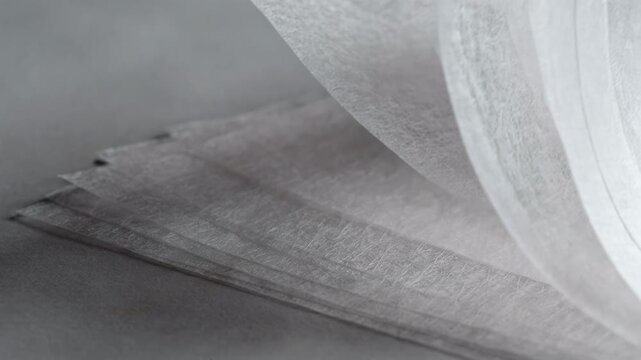 Medium shot of ultrathin specialty lens tissue sheets neatly fanned out highlighting the delicate texture of ultrasoft paper designed for precise optical cleaning.