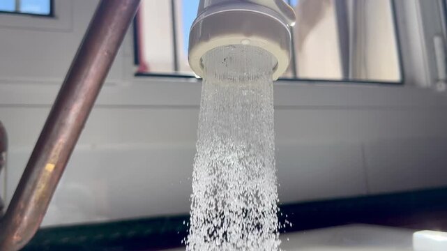 Water flowing from faucet for sustainability and conservation. Clean water in a house's kitchen