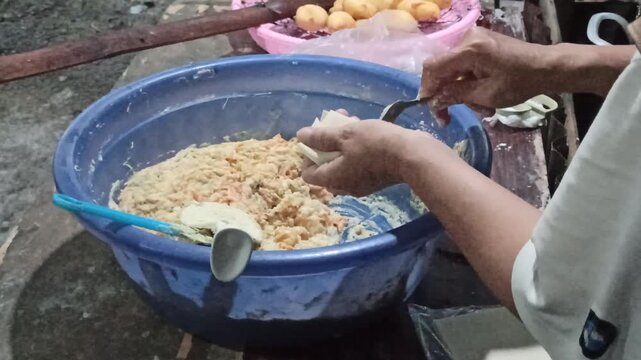 A close-up of siomay wrappers being carefully filled with seasoned dough, ensuring consistent portioning, balanced texture, and proper sealing before frying to achieve optimal structure and flavor.