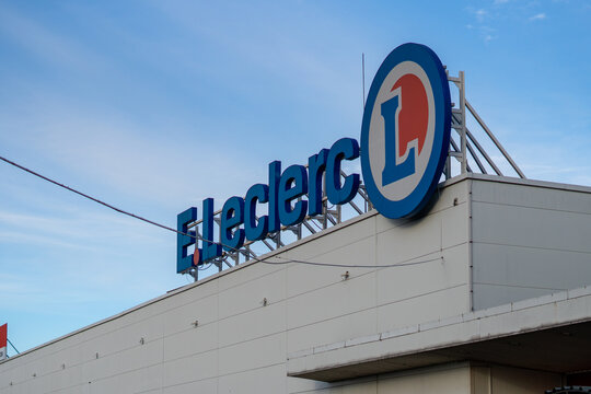 Large blue E.Leclerc supermarket signage and logo mounted on a white retail building roof against a clear blue sky, representing commercial grocery infrastructure in Poland.