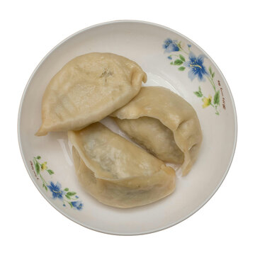steamed Chinese dumplings (Jiaozi) served on a white floral-patterned ceramic plate