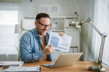 Fototapeta premium Man presenting sales data during video call from home
