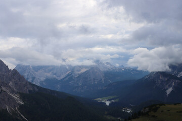 Fototapeta premium Dolomite ridges captured with heavy clouds above peaks along alpine hiking path