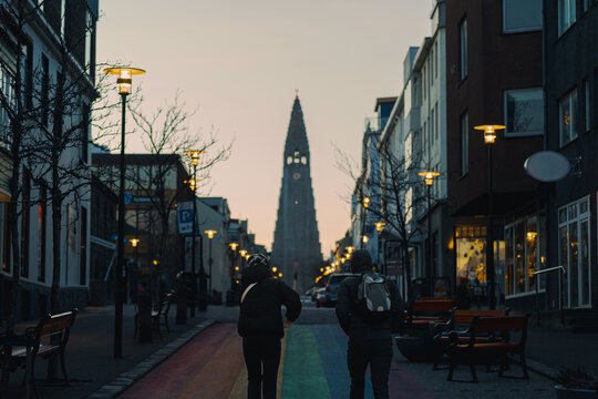 Unrecognizable tourists walking up the Rainbow Street towards the church at dawn.